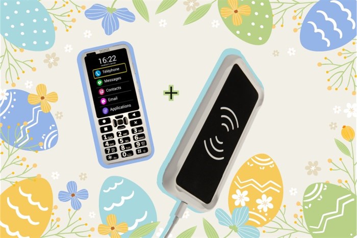 Zdjęcie przedstawia planszę na której umieszczone są wielkanocne pisanki. W centralnej części znajduję się telefon Kapsys SmartVision 3 oraz ładowarka.